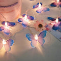 Guirnalda de mariposas moradas encendida sobre una mesa de mármol rosa