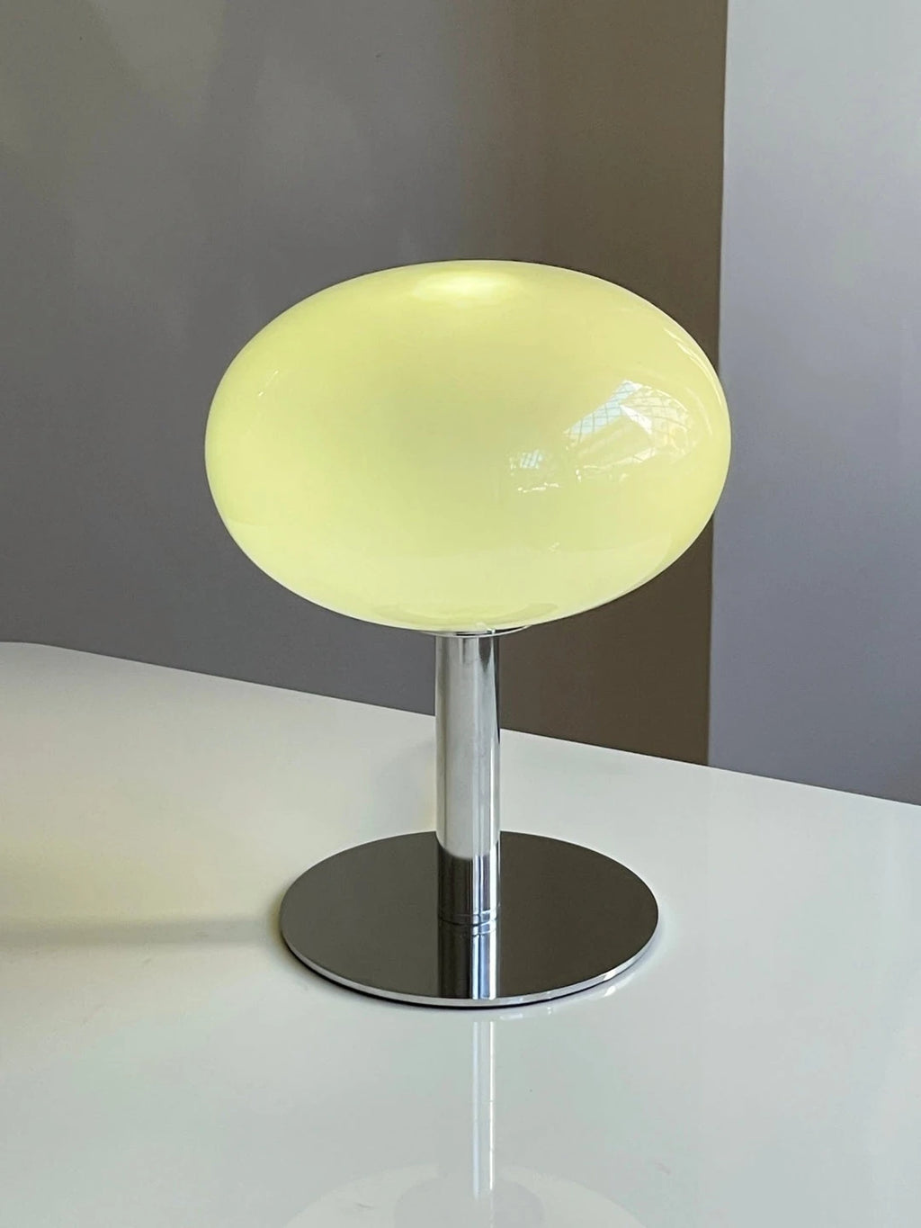 Lumi Moon beige encendida sobre una mesa blanca
