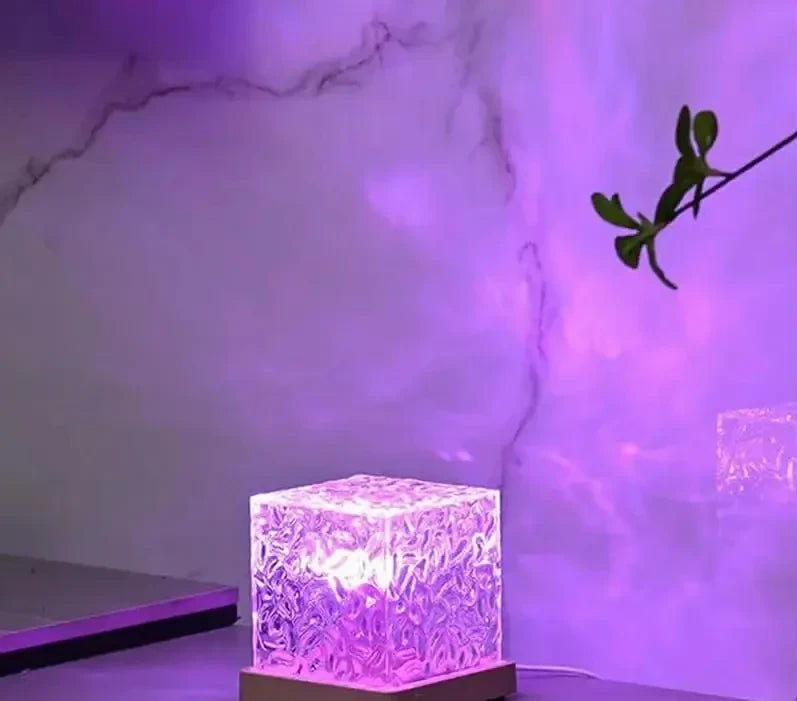 Wave Lume en rosa sobre un mueble, con las ondas proyectadas en la pared